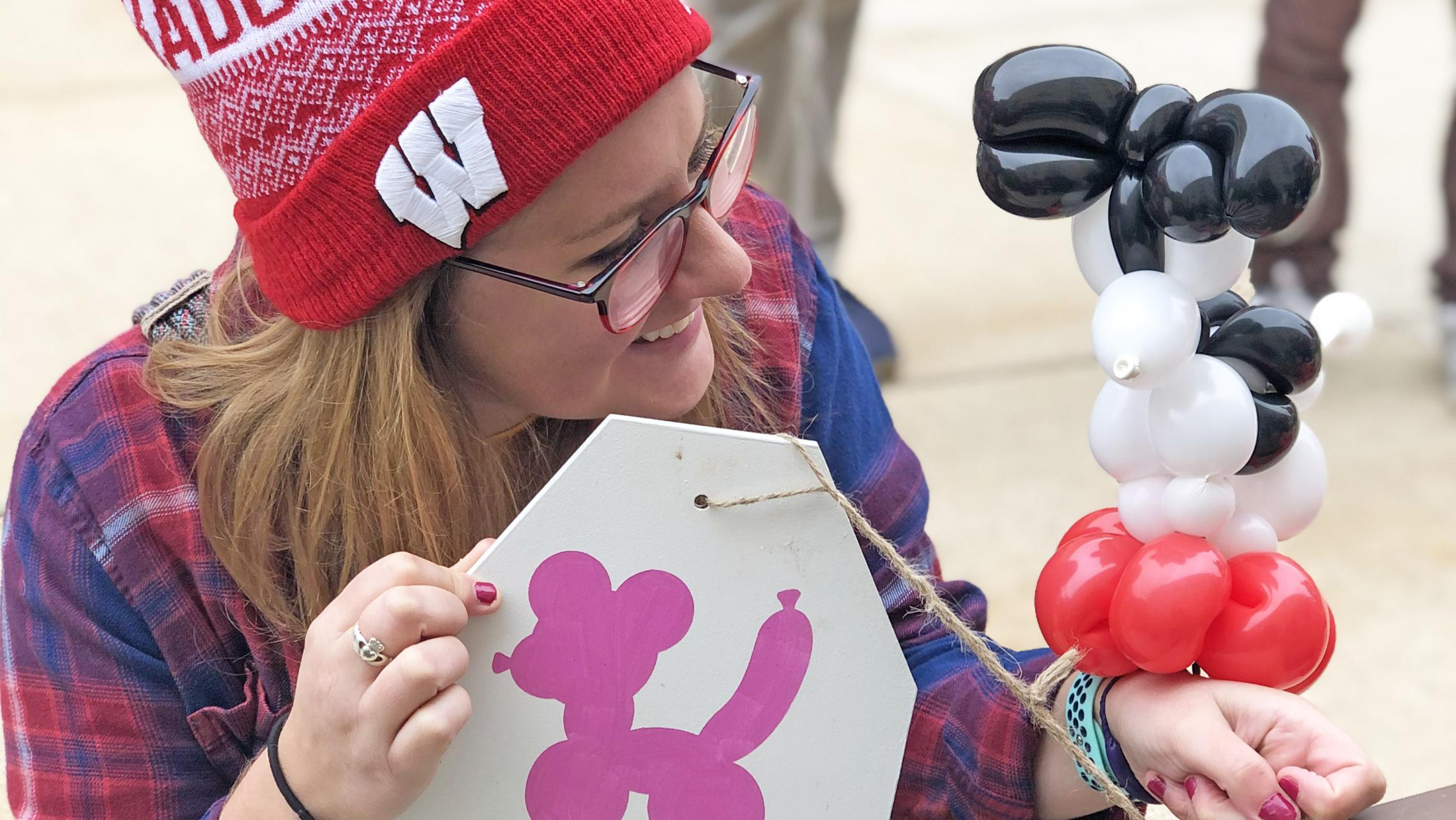 Residents enjoying ULI's second annual tailgate during the Wisconsin Badgers Football Game with balloon figures from Funny Faces