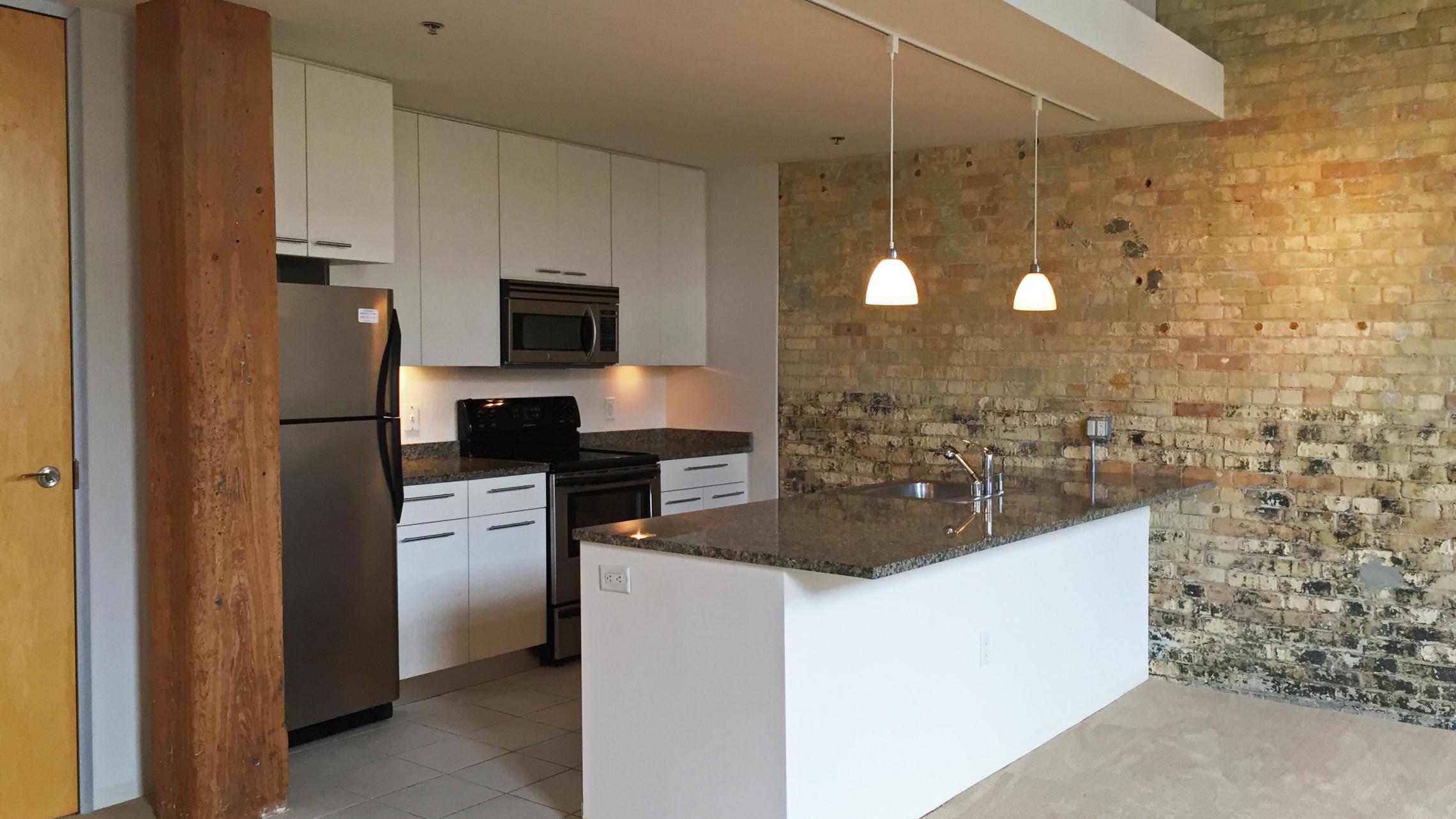 ULI Tobacco Lofts - E208 - Exposed Brick and Beams in Kitchen