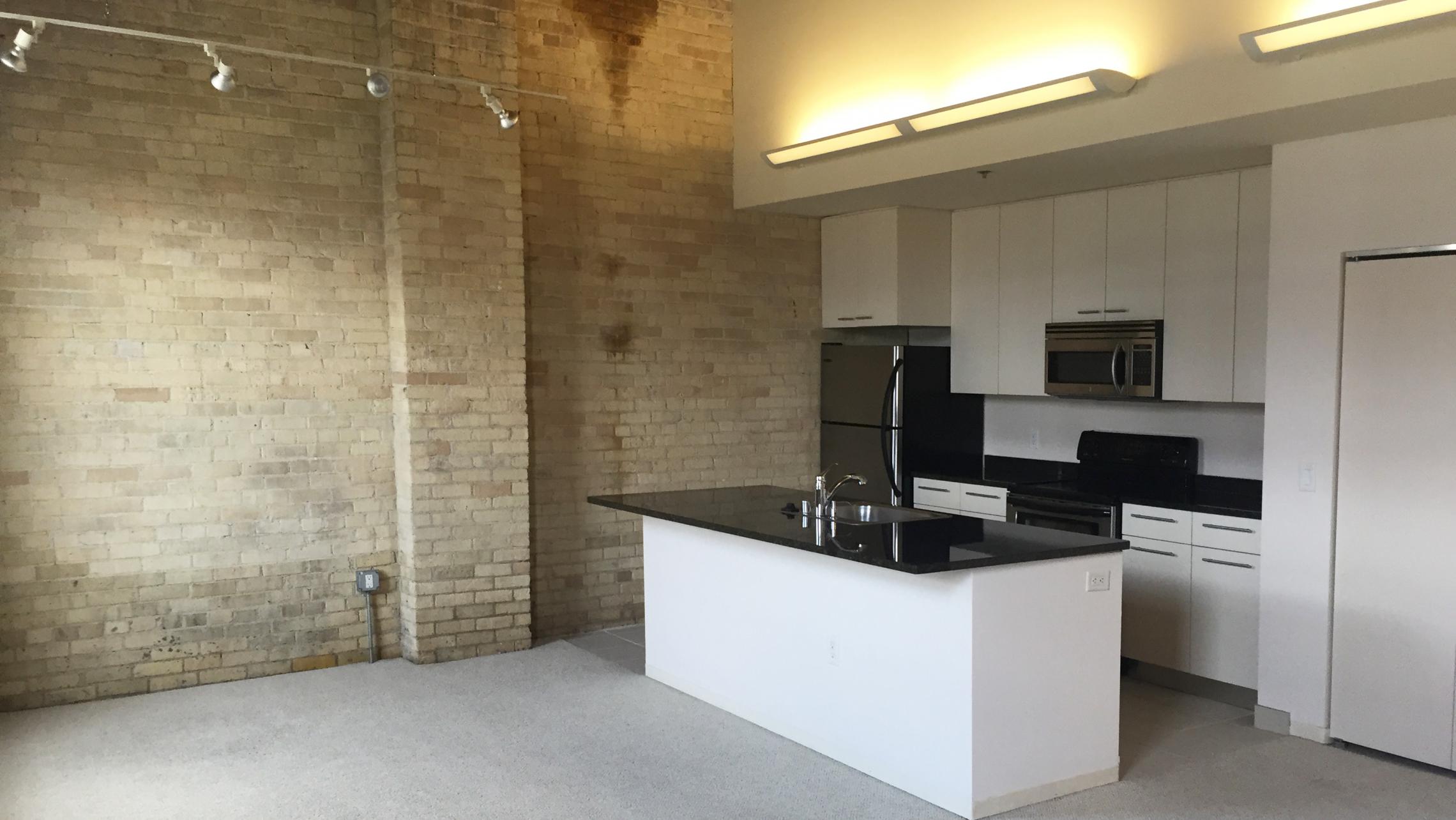 ULI Tobacco Lofts - E309 - Kitchen with Exposed Brick